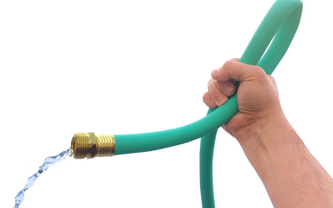 a hand squeezing a water hose, creating a kink